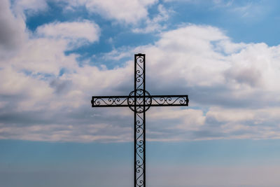 Low angle view of silhouette sign against sky