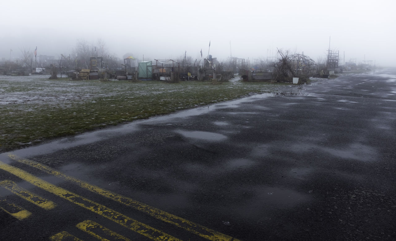 WET ROAD AGAINST SKY DURING WINTER