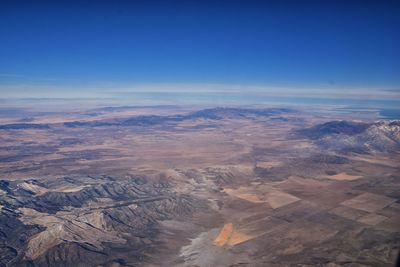 Aerial view of dramatic landscape against blue sky