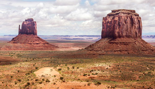 Rock formations on landscape against cloudy sky