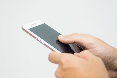 Close-up of hand holding smart phone over white background