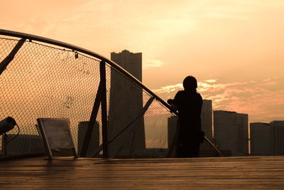 Silhouette man standing against sky during sunset