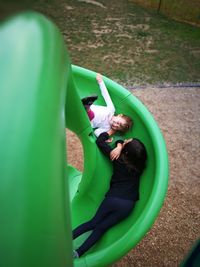 High angle view of playful sisters on slide