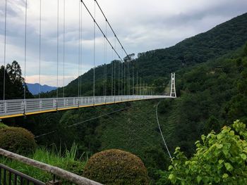 Bridge over mountain against sky