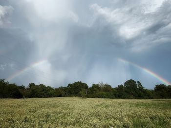 Scenic view of rainbow over field against sky