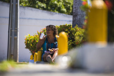 Full length of man sitting on yellow flower