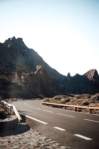 Road by mountain against clear sky