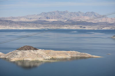 Scenic view of lake by mountains against sky