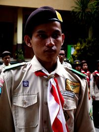 Young man wearing uniform standing outdoors