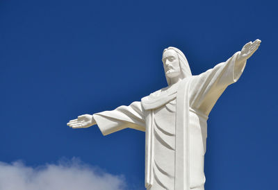 Low angle view of jesus christ statue against blue sky