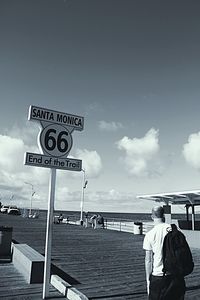 People at seaside against cloudy sky