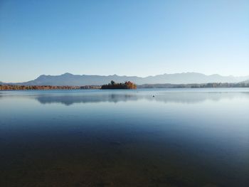 Scenic view of lake against clear blue sky