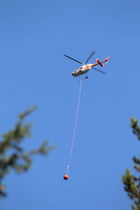Low angle view of helicopter flying in sky