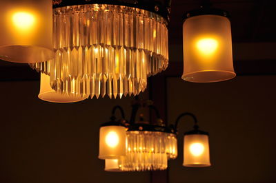 Low angle view of illuminated light bulbs hanging from ceiling