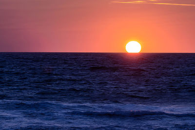 Scenic view of sea against orange sky