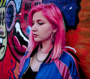 Portrait of young woman against wall