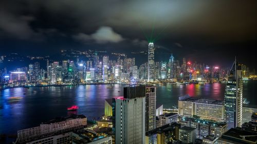 High angle view of victoria harbor amidst illuminated buildings