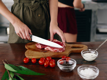 Midsection of woman having food on table