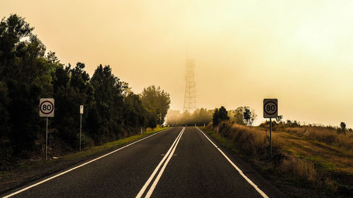 Road amidst trees against clear sky