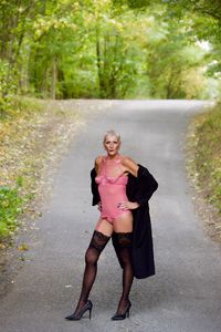 Portrait of confident woman in dress standing on road