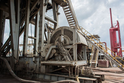 Low angle view of industry against sky