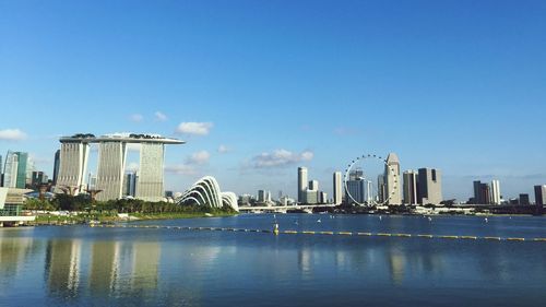 City at waterfront against blue sky