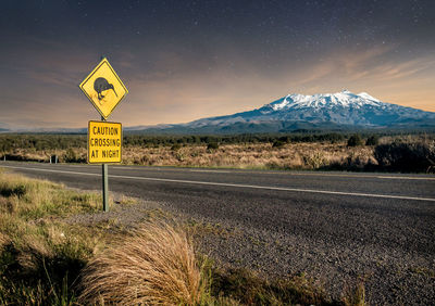 Kiwi road sign with snow covered mount ruapehu against starry sky