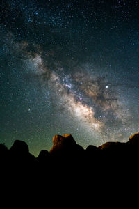 Low angle view of silhouette mountain against sky at night