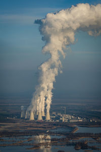 Smoke stack in factory against sky