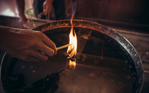 Cropped hand burning candle