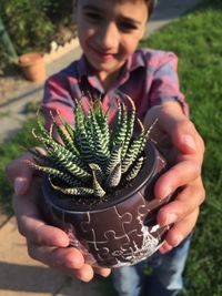 Close-up of woman holding plant