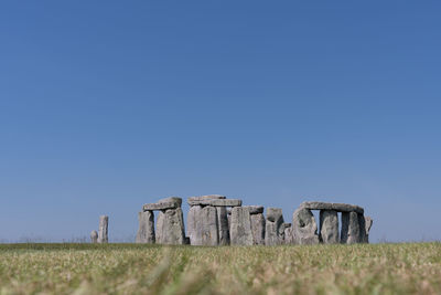 Old ruin on field against clear blue sky