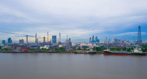 River by buildings in city against sky