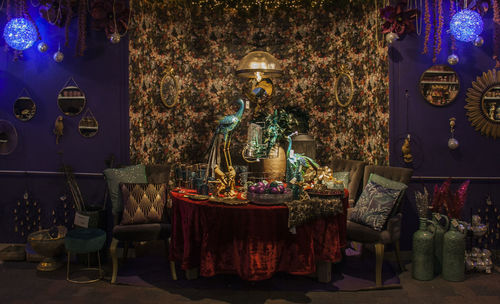 Illuminated decorated table against wall at temple