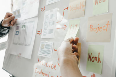 Midsection of people holding text on paper