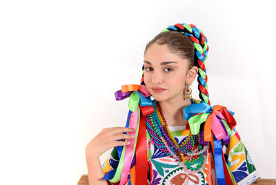 Portrait of young woman holding multi colored background