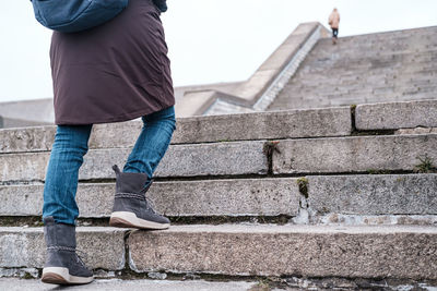 Low section of man standing on staircase