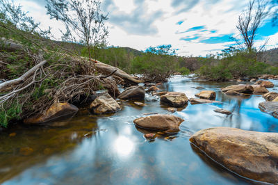 Rocks in lake against sky