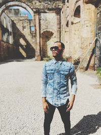 Full length of young man wearing sunglasses standing in city