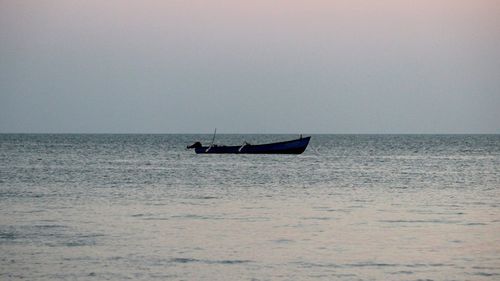 Boat sailing in sea against clear sky