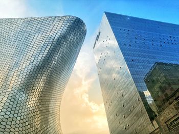 Low angle view of modern buildings against sky during sunset