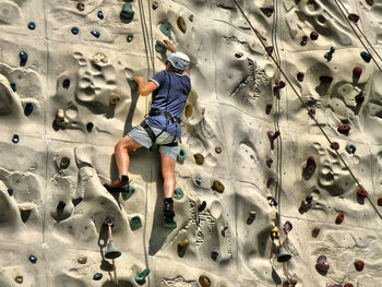 Rear view full length of man climbing wall