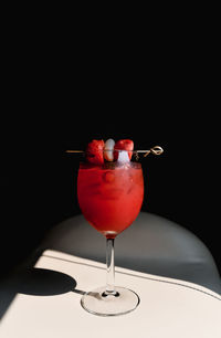Close-up of red wineglass on table against black background