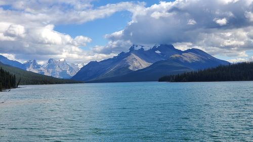 Scenic view of lake by snowcapped mountains against sky