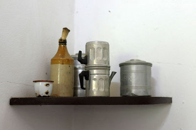 Close-up of wine bottles on table against wall