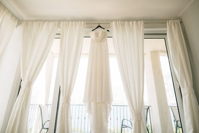 Low angle view of white curtain on window