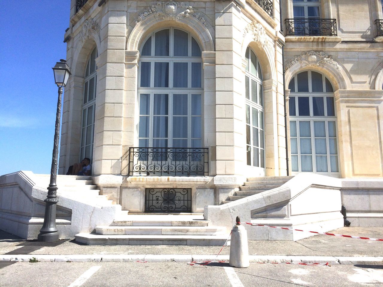 building exterior, architecture, built structure, low angle view, window, facade, building, city, steps, arch, day, sunlight, travel destinations, sky, outdoors, architectural feature, entrance, history, architectural column, street light