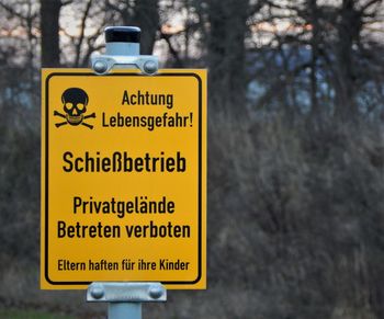 Close-up of road sign against trees