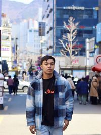 Portrait of young man standing in city