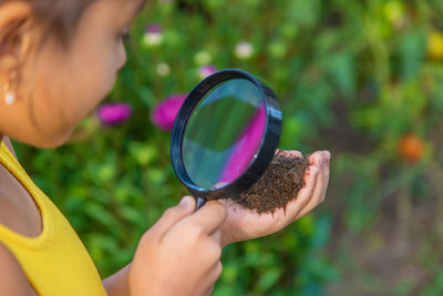 Close-up of hand holding magnifying glass